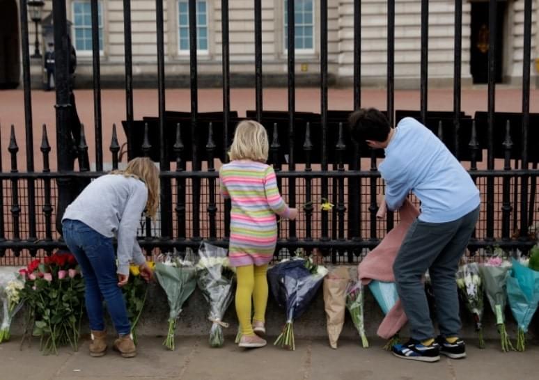 Aficionados reales depositan flores en homenaje al príncipe Felipe frente al Palacio de Buckingham Crédito AP