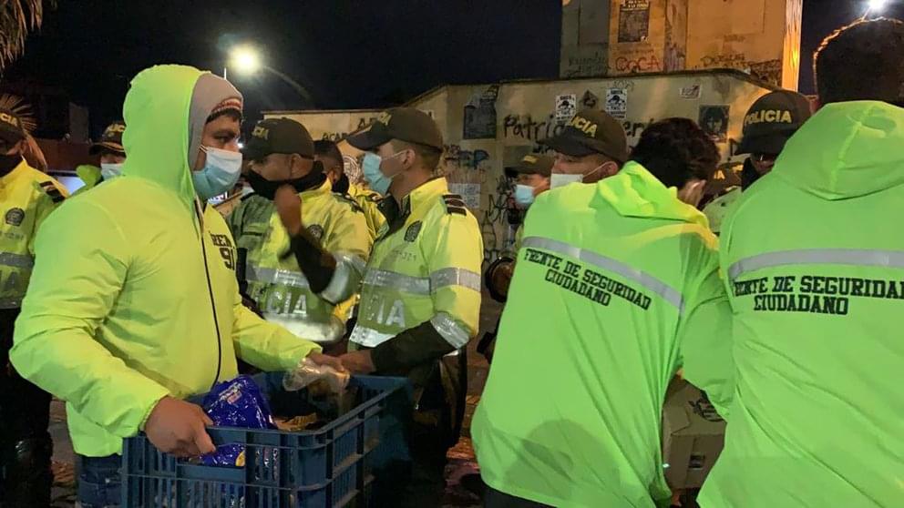 Los jóvenes aguateros le llevan comida a los policías.