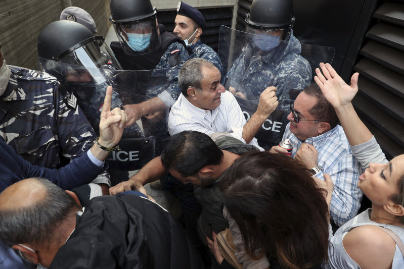 Los clientes del banco se pelean con la policía antidisturbios cuando intentan asaltar un banco de Beirut en noviembre