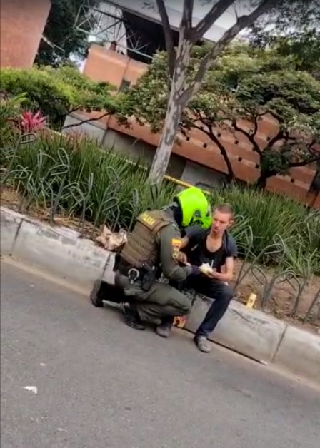 Patrullero le da de su comida a un habitante de calle.