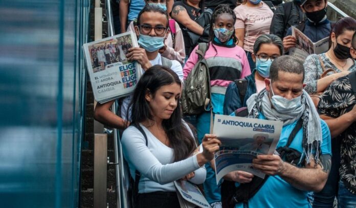 Ciudadanos de Medellín reciben periódicos del Pacto Histórico en las escaleras del Metro