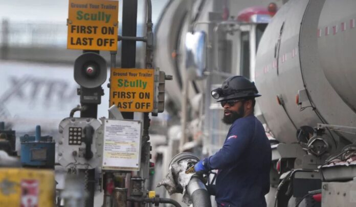 Un conductor descarga petróleo crudo de su camión cisterna para convertirlo en gas en la refinería Marathon, Estados Unidos