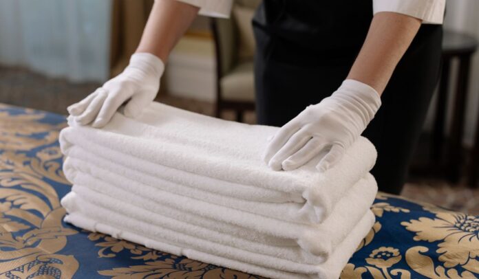 Trabajador organiza toallas en un hotel