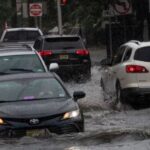Los automóviles circulan por las calles inundadas a medida que se acerca la tormenta tropical Henri, en Hoboken, Nueva Jersey, el 22 de agosto de 2021.
