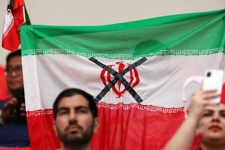 La seguridad del estadio obligó a un aficionado a quitarse la cruz negra que había pegado a la bandera iraní