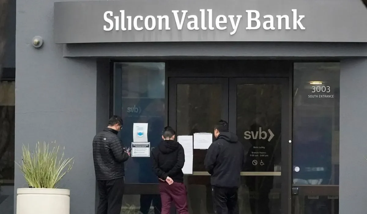 La gente mira los carteles colocados afuera de la entrada de Silicon Valley Bank en Santa Clara, California, el viernes.