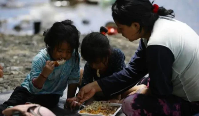 Migrantes en la selva del Darién comiendo pollo frito