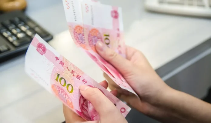 Mujer contando billetes de 100 yuanes